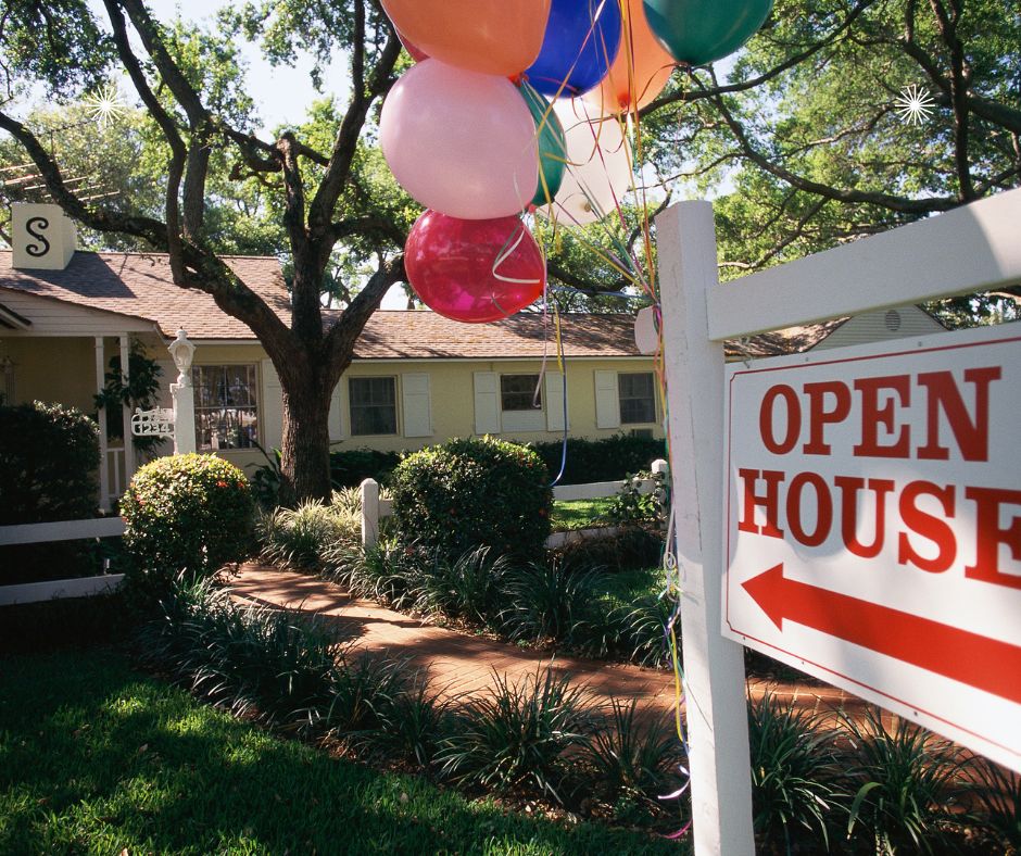a house with an open house sign and balloons tied to the sign