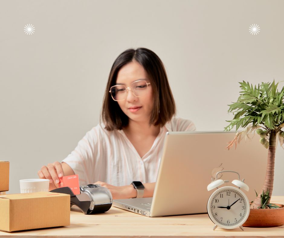 woman sitting in front of an open computer with a clock in front of the computer