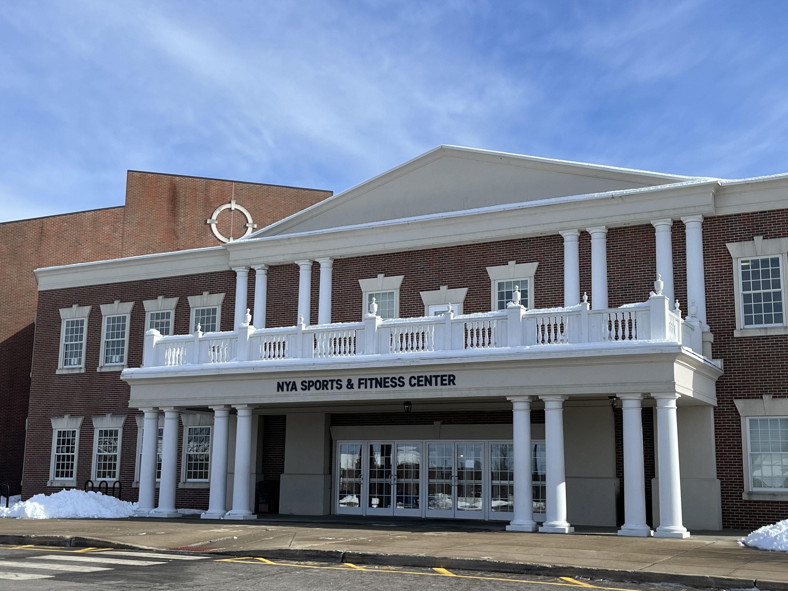 Picture of an old brick building with white portico in front