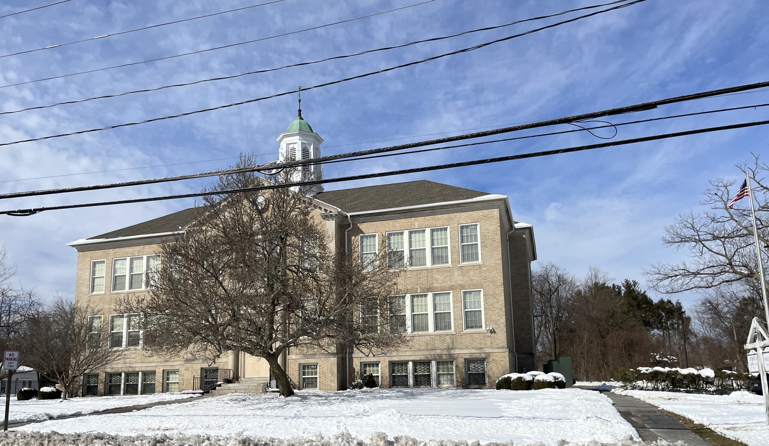 picture of a winter scene with a sandstone schoolhouse at its center