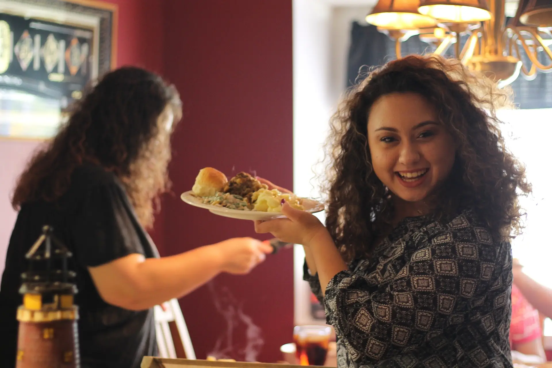 two women serving dinner and smiling